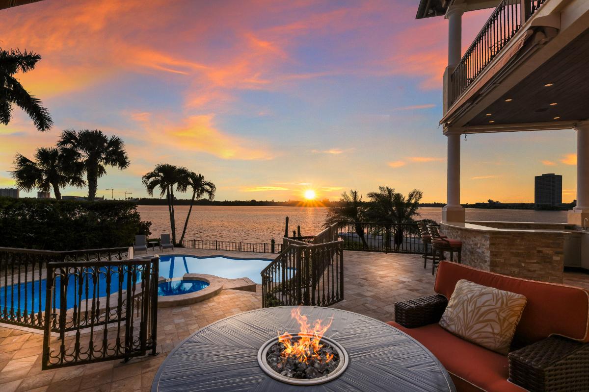 Patio with a fire pit , pool overlooking the water.