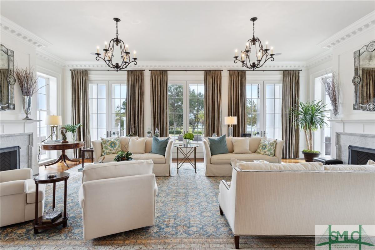 Living room with chandeliers, couches and a fireplace.