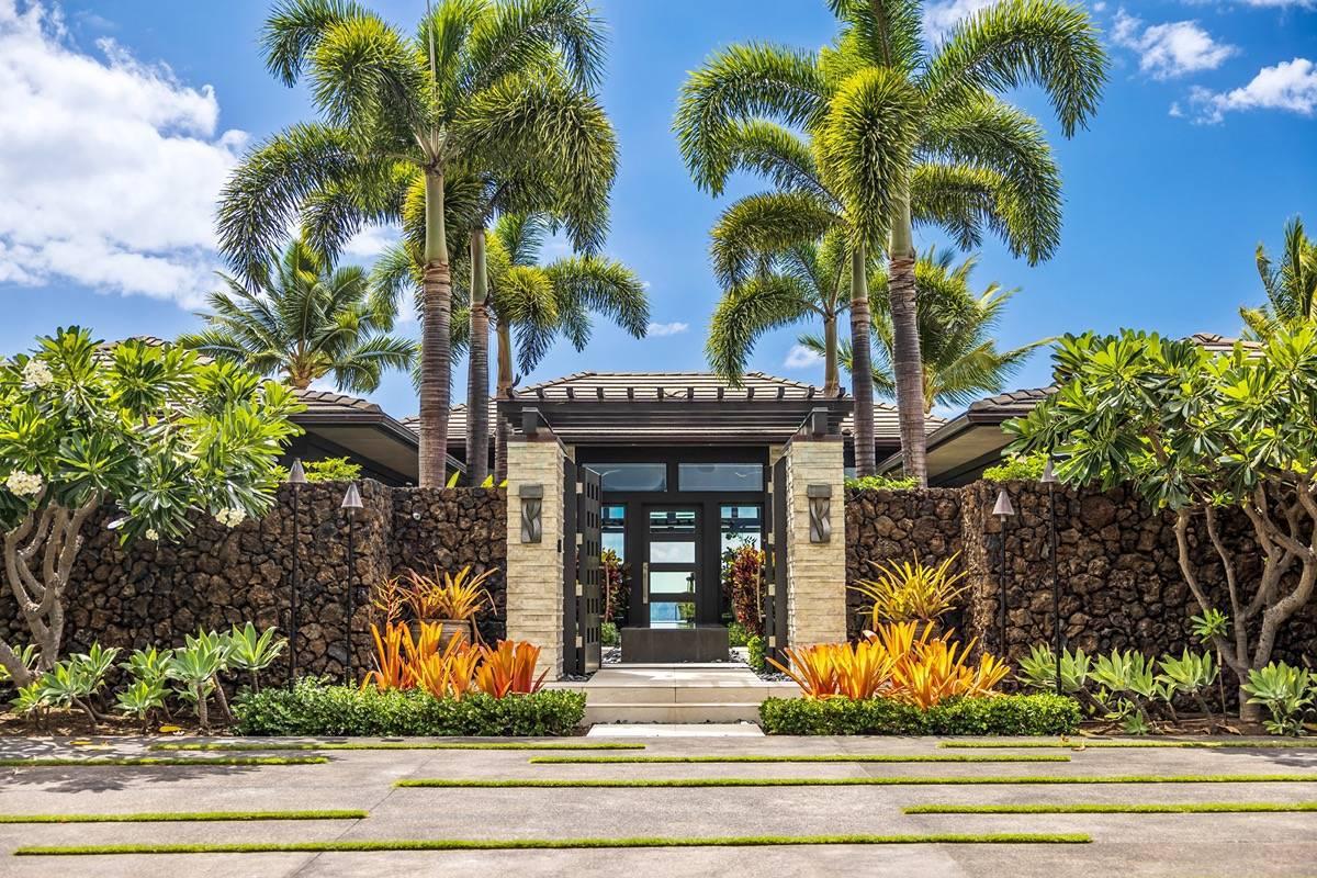Front gate entry of the mansion with plants and trees.
