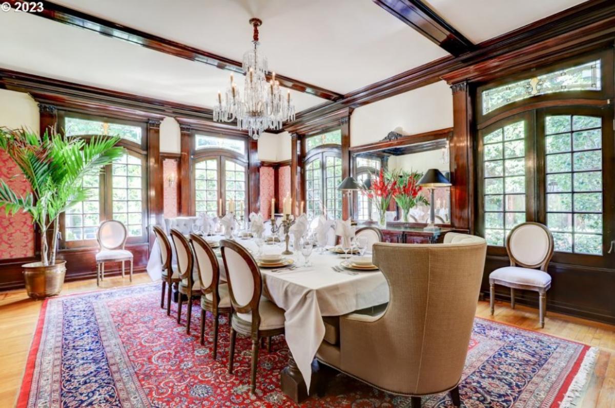 Dining room with a chandelier and glass windows.