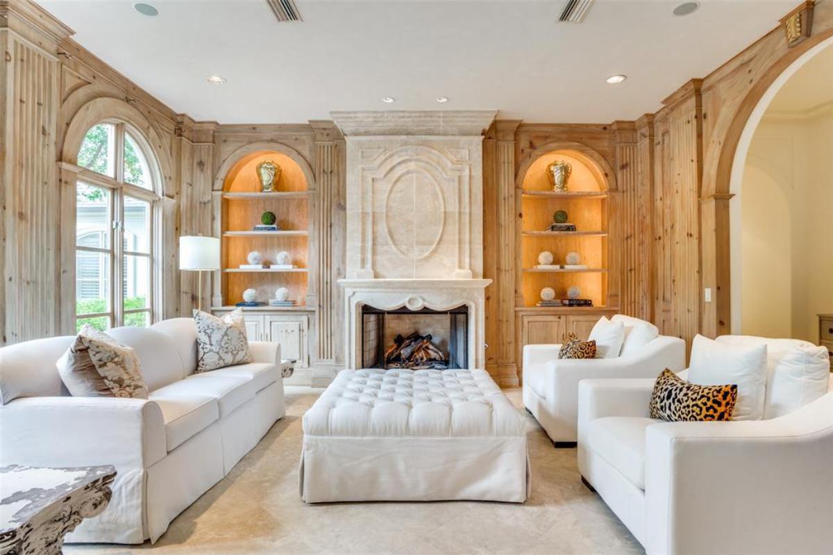 Living room with couches, custom lights and a fireplace.