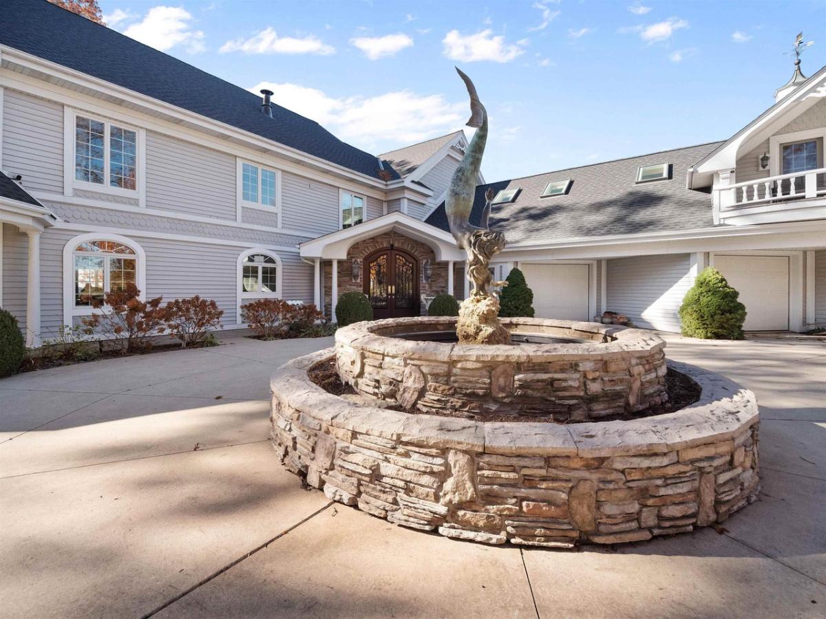 Front view of the mansion with a stone fountain.