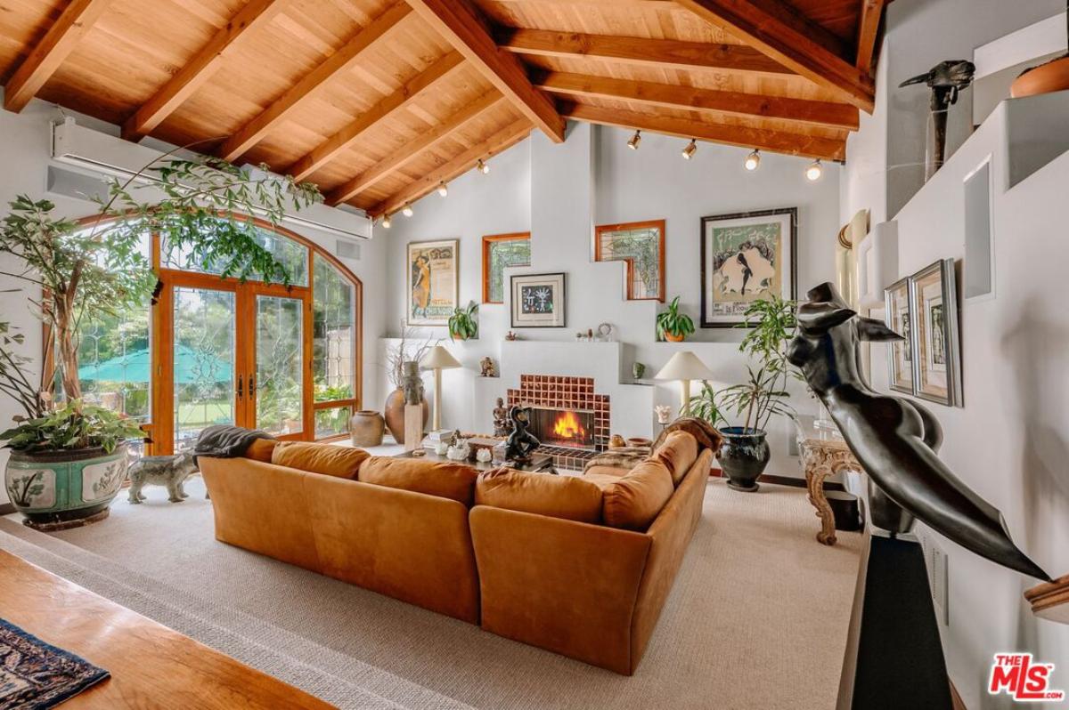 Living room with couches, glass doors, and a fireplace.