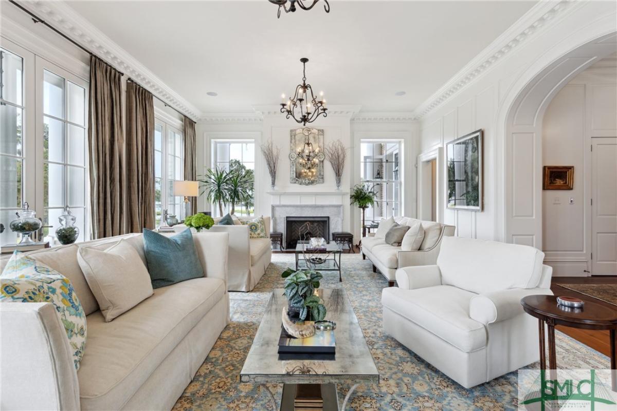 Living room with chandeliers, couches and a fireplace.
