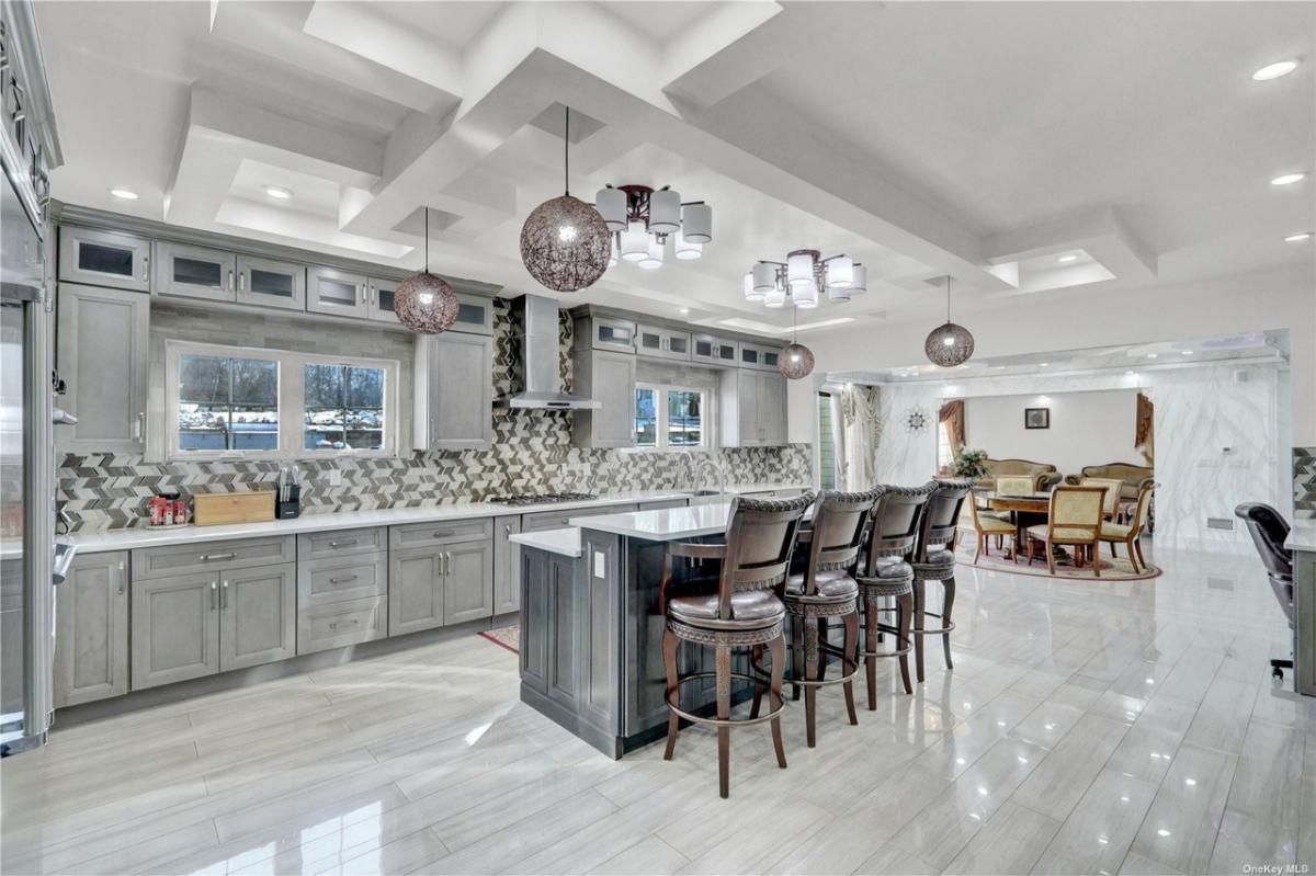 Kitchen with tile flooring custom lighting and custom cabinetry.