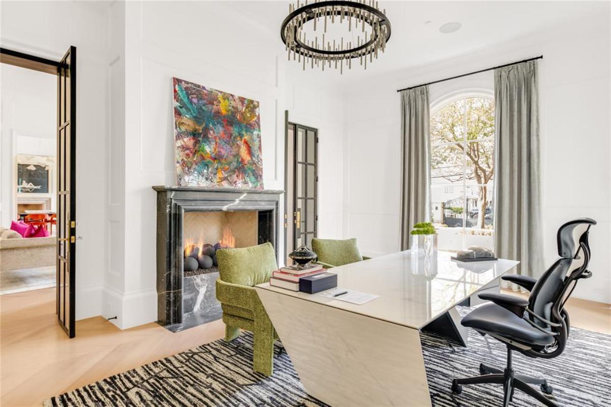 Home office with a chandelier and a fireplace.