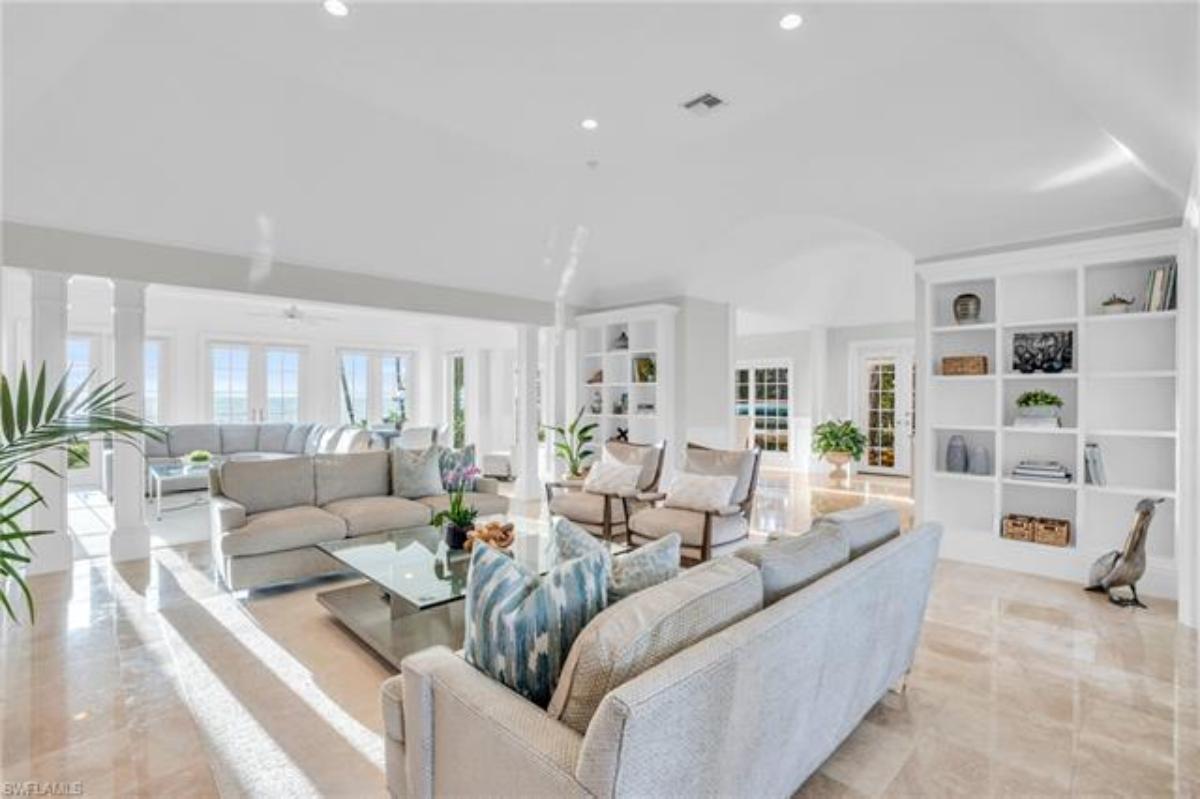 Living room with couches, shelves, glass windows and custom lights.
