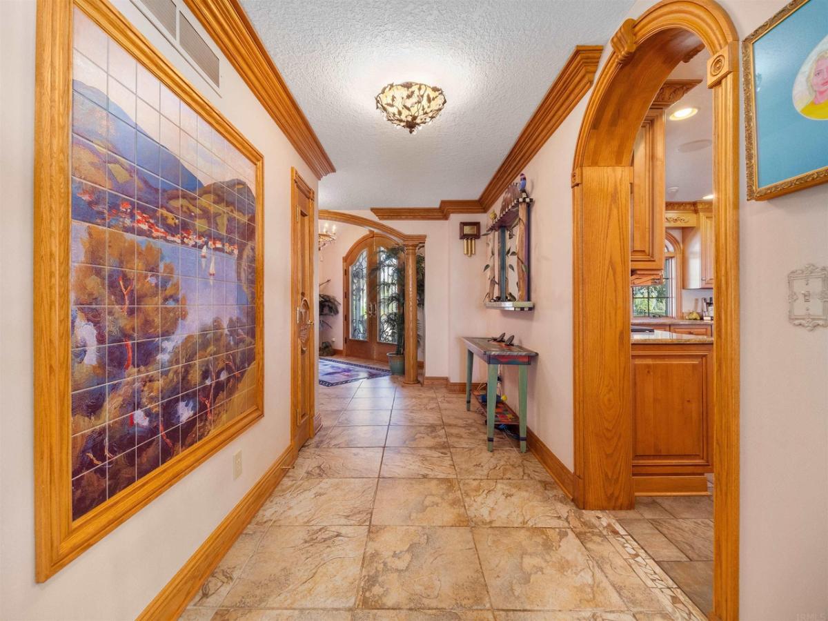 Hallway with glass doors and a large frame on the wall.