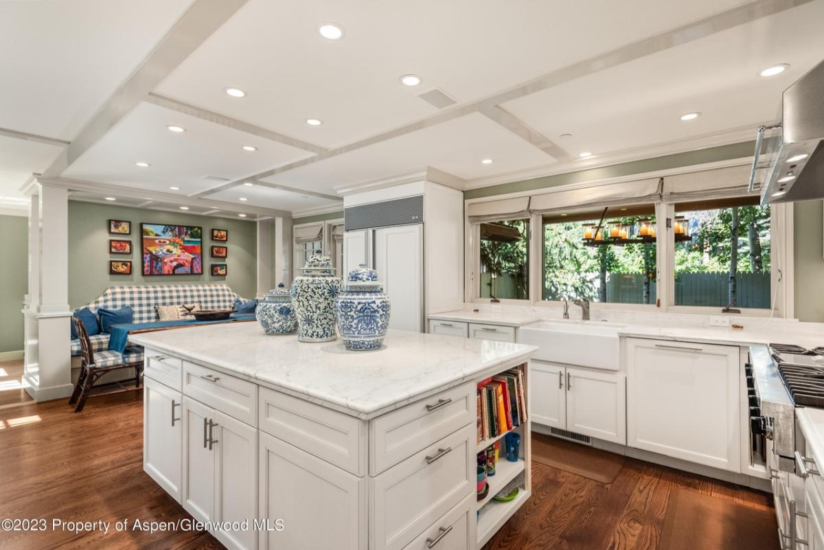 Kitchen with a large island, wooden floor, custom lights and custom cabinets.