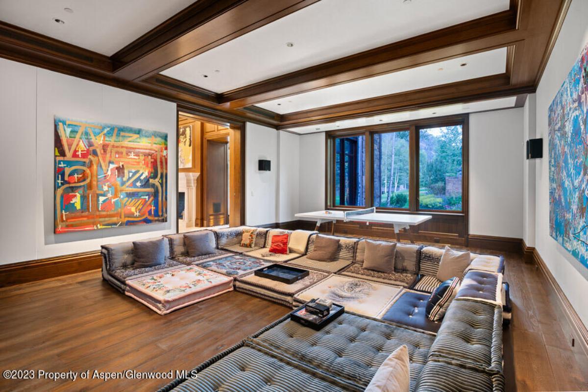 Living room with couches, glass windows and a wooden floor.