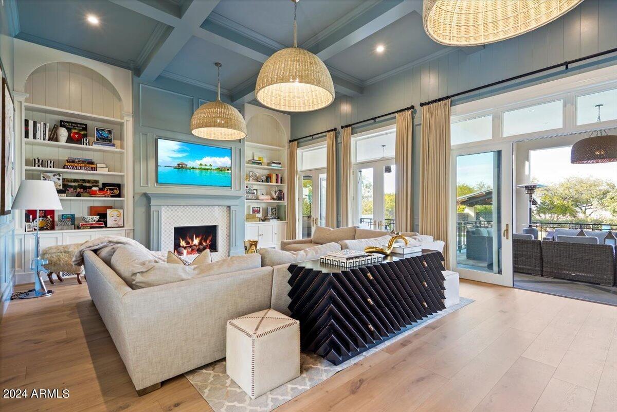 Living room with couches, TV, glass door, glass windows and a fireplace.