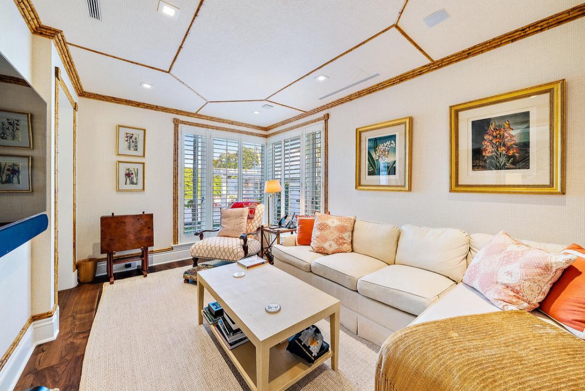 Living room with a couch, wooden floor and a large rug.