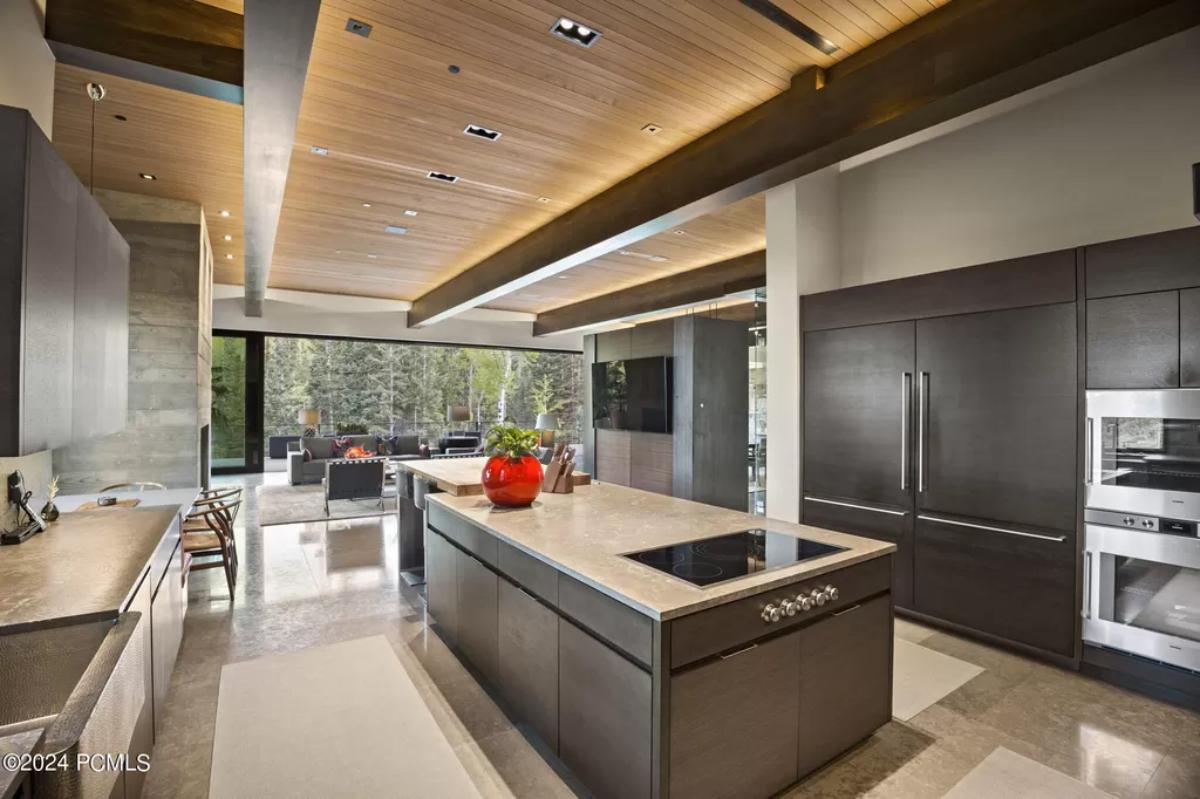 Kitchen with a large island, wooden ceiling and custom lights.
