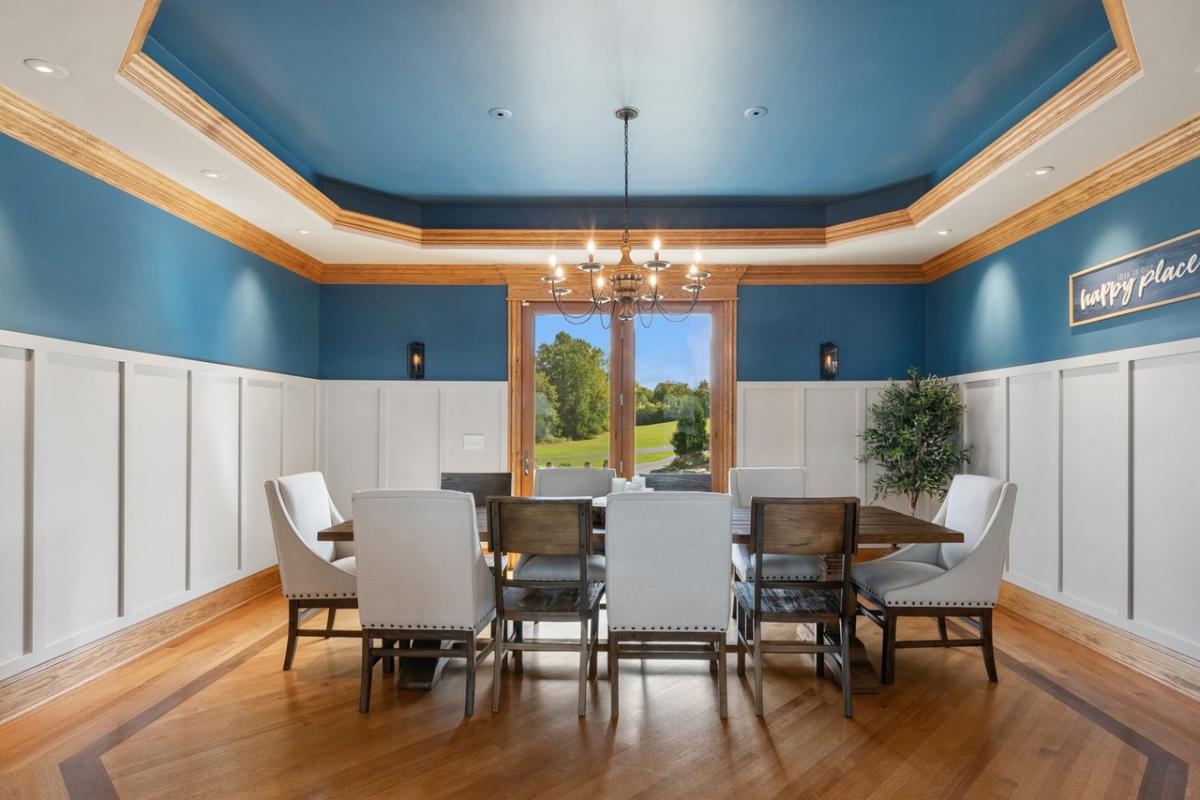 Dining room with wood flooring and a chandelier.