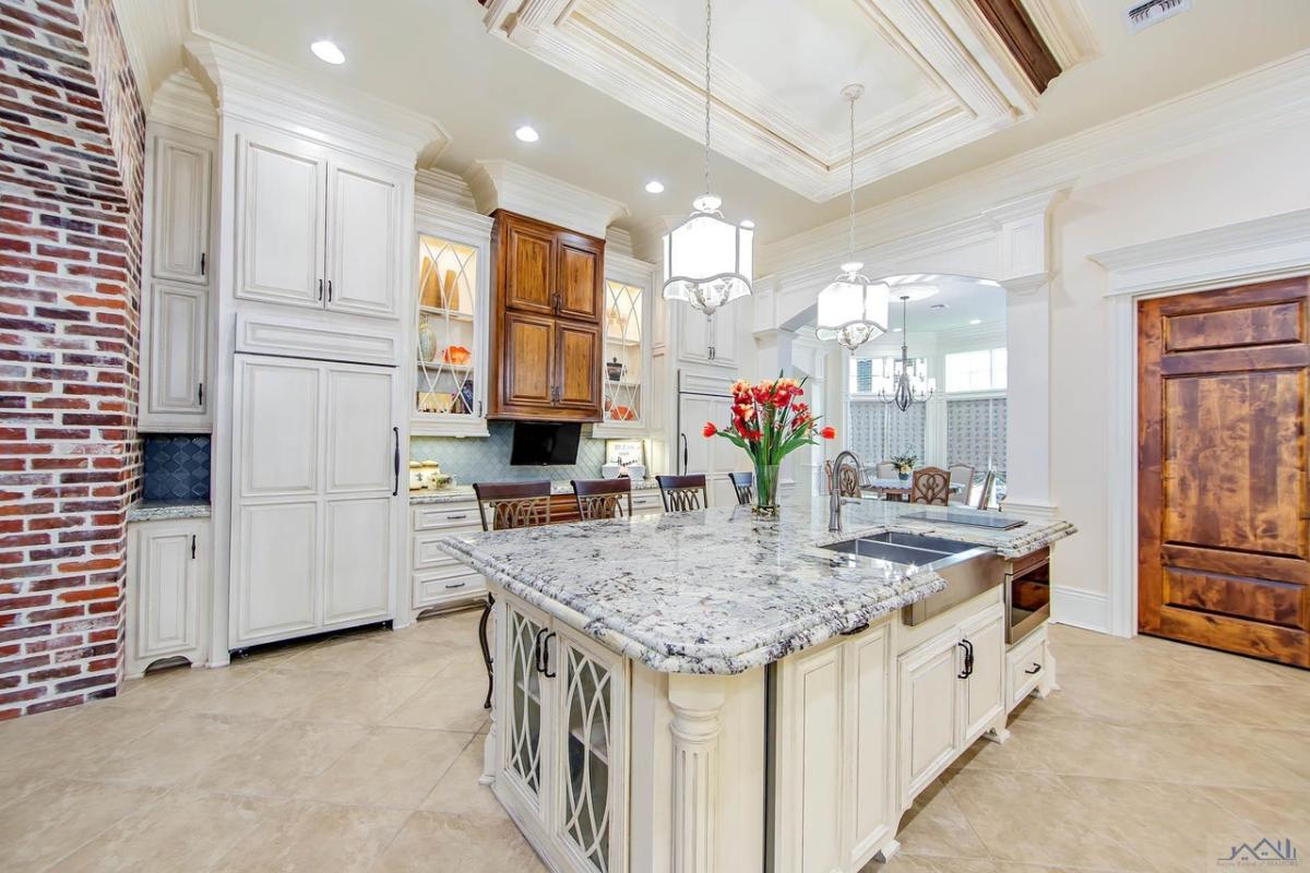Kitchen with a large island, custom lights and custom cabinets.