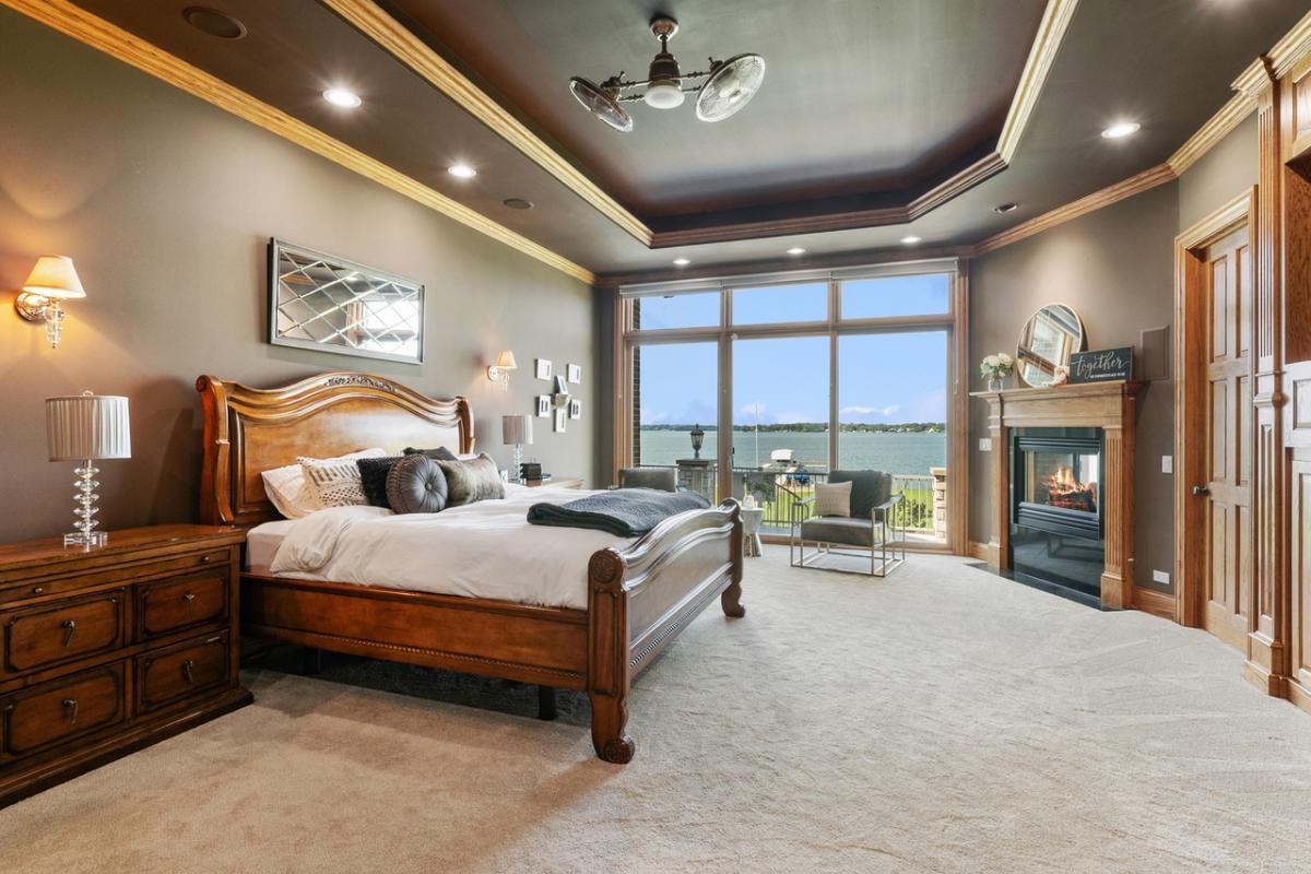 Bedroom with carpet flooring, sliding glass doors and a fireplace.