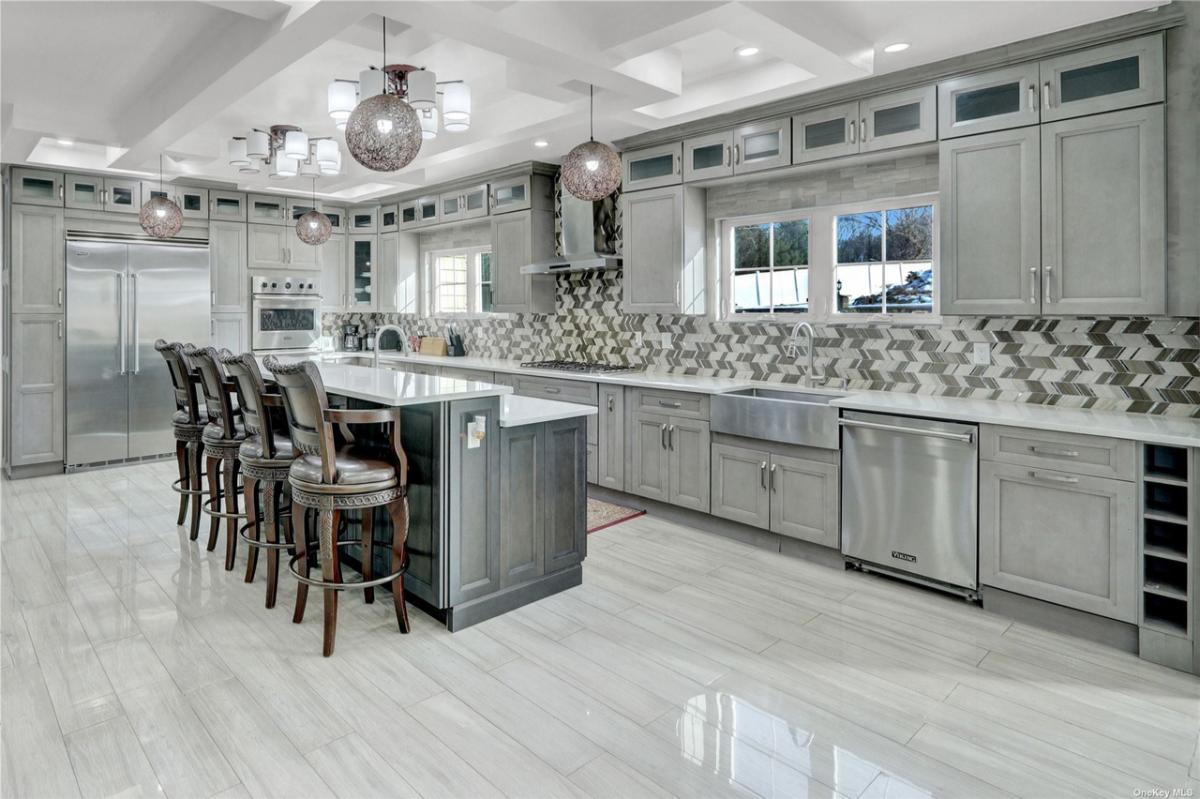 Kitchen with tile flooring custom lighting and custom cabinetry.
