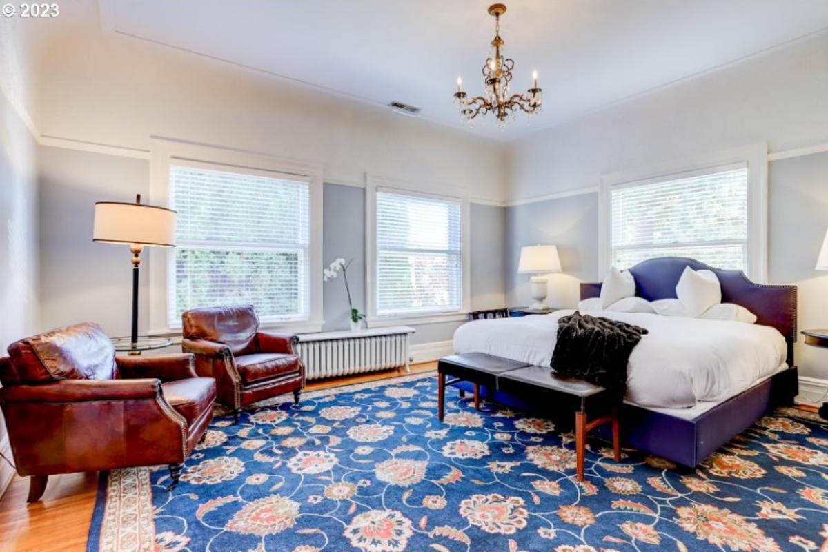 Bedroom with a chandelier, couches and a large rug.