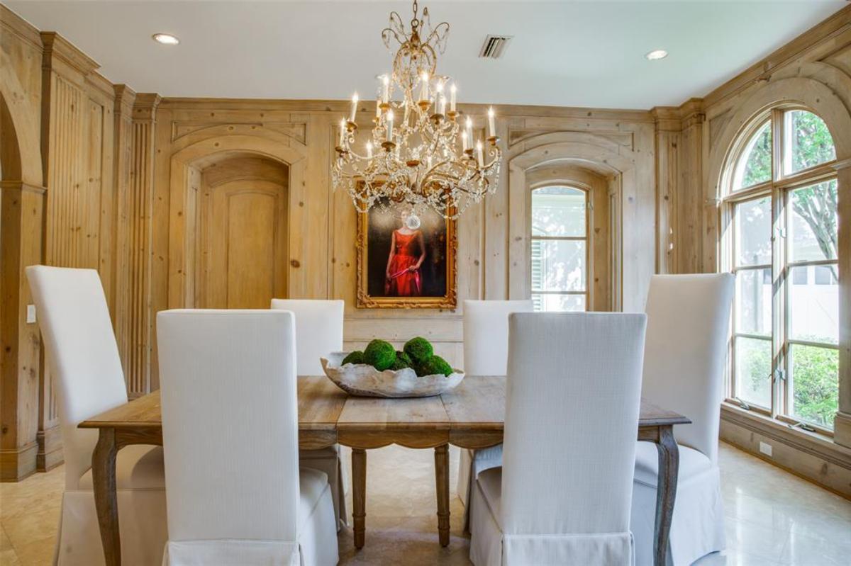 Dining room with wooden table and a chandelier.