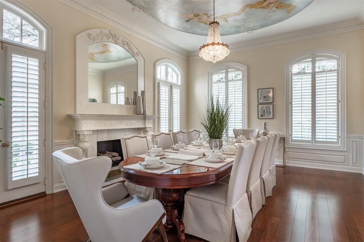 Dining room with a large wooden table and a chandelier.