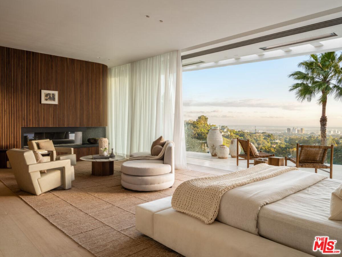 Bedroom with a fireplace, living space and a balcony.