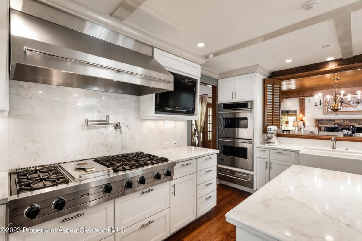 Kitchen with a stove ,wooden floor and custom lights.