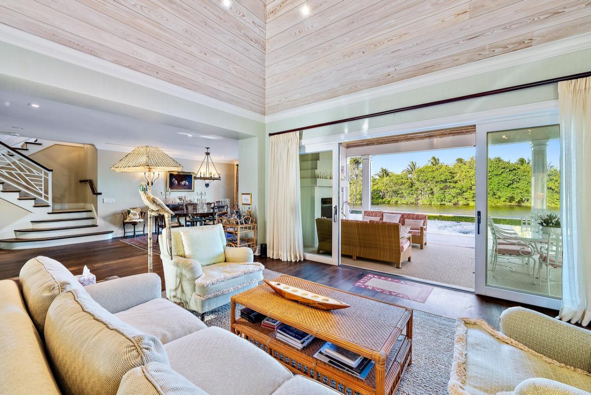 Living room with a couch, large sliding glass door that opens out to the backyard.