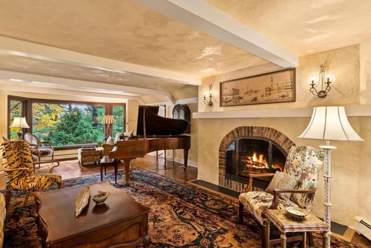 Great room with a piano and a fireplace.
