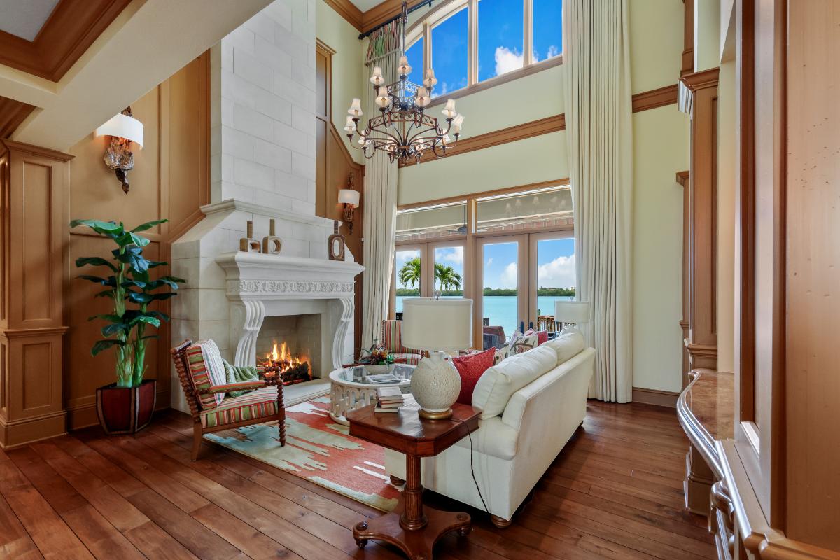 Living room with a couch, glass doors, fireplace and a large rug.