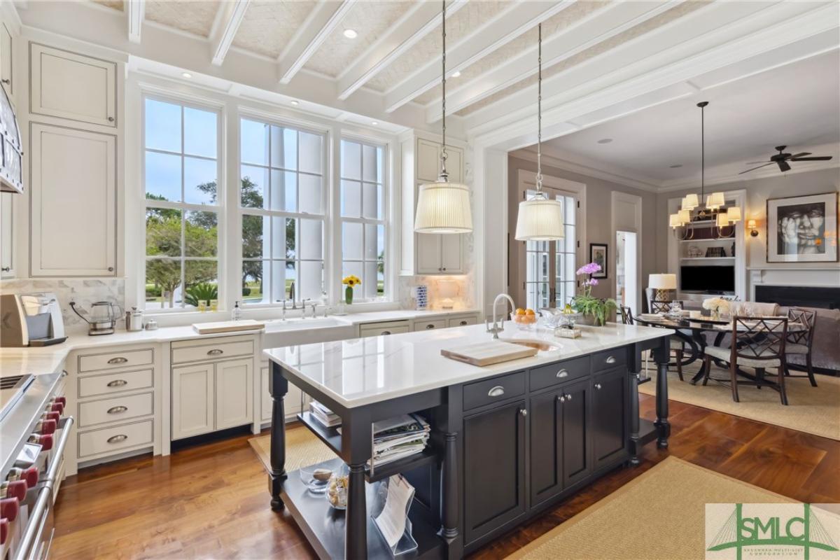 Kitchen with a large island, open beam ceiling and custom cabinetry.