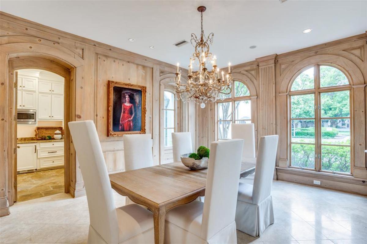 Dining room with wooden table and a chandelier.
