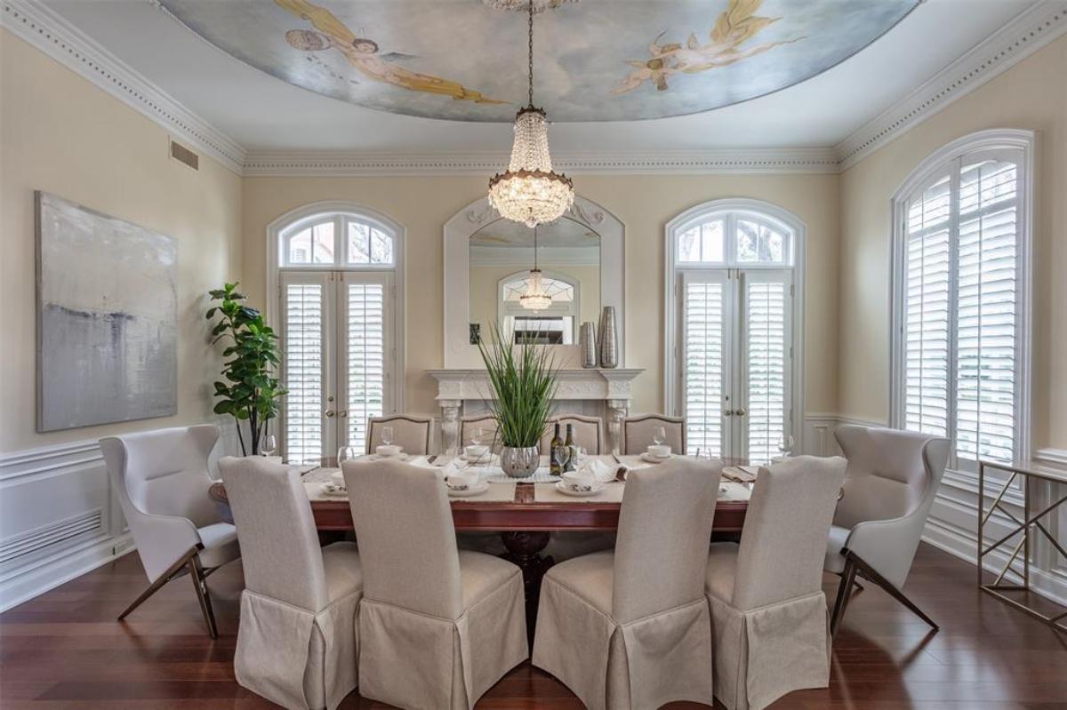 Dining room with a large wooden table and a chandelier.