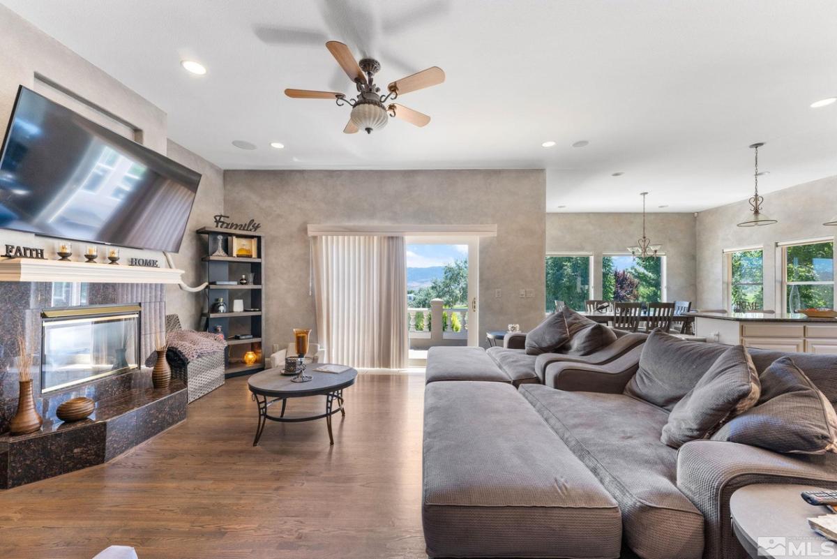 Media room with a couch, TV, glass windows, fireplace and custom lights.