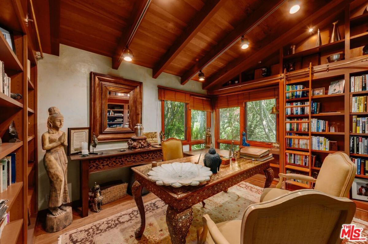 Home office with a desk, chairs, custom lights, bookshelf and a large rug.