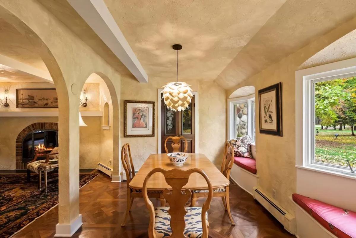 Breakfast nook with wooden table and glass windows.