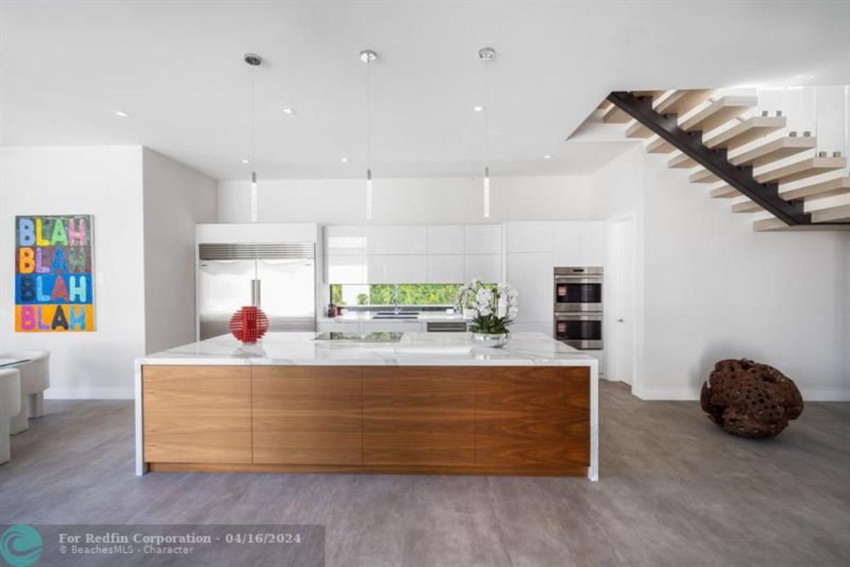 Kitchen with a large island, custom lighting and custom cabinetry.