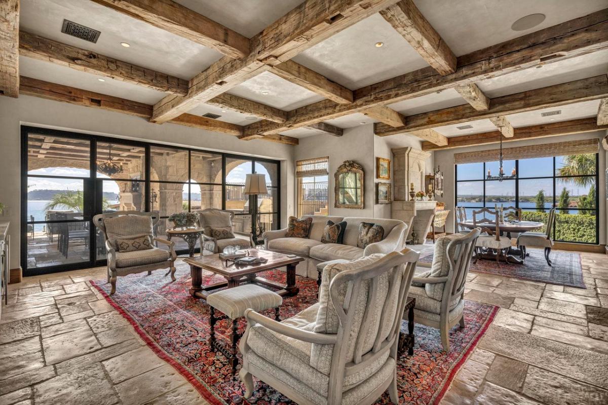 Living room with sofas, tables, and antique French limestone floors.