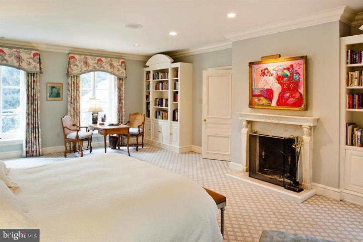 Bedroom with carpet flooring and a fireplace.