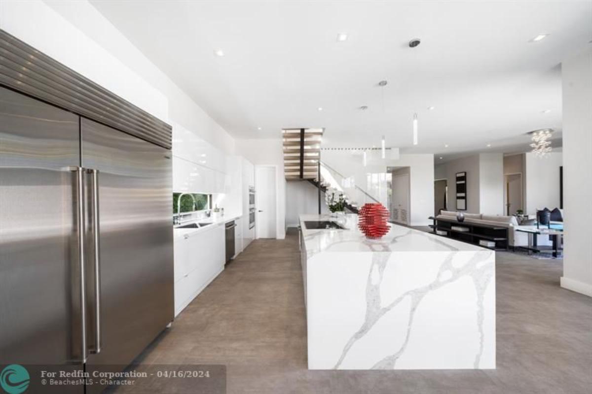 Kitchen with a large island, custom lighting and custom cabinetry.