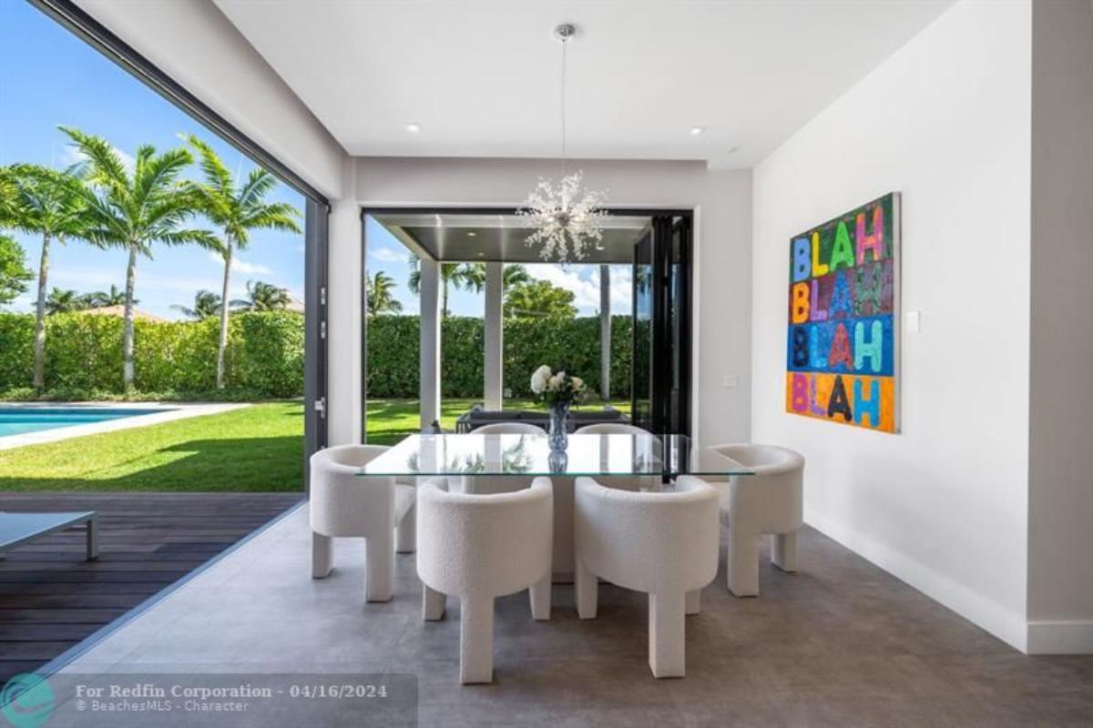 Dining room with a chandelier, glass table and chairs.