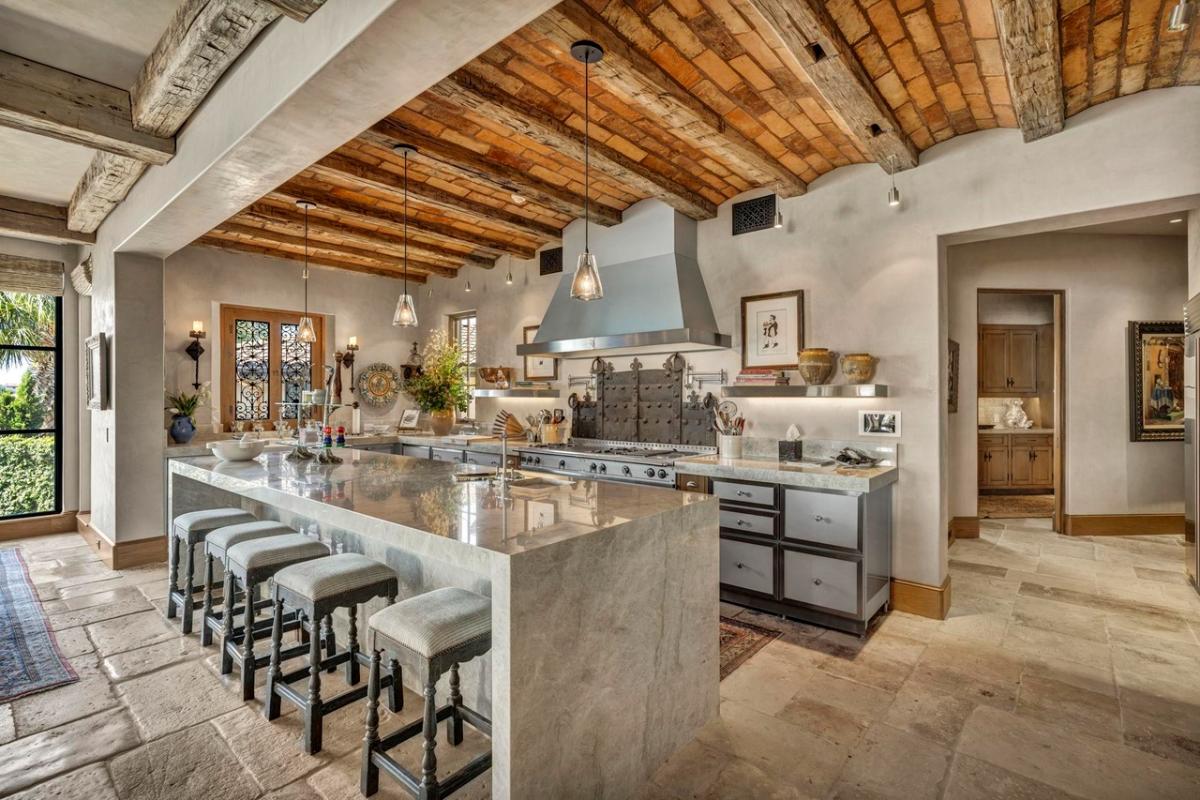 Kitchen with a large island, wood ceiling beams and custom cabinetry.