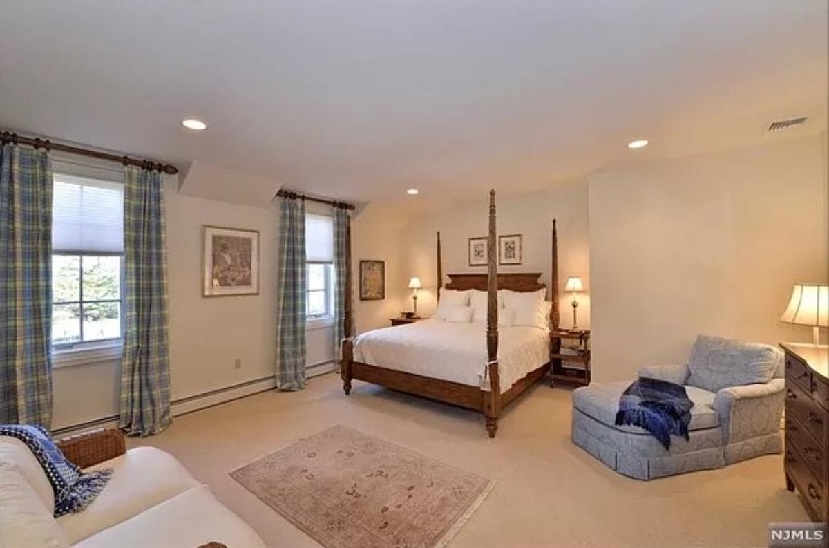Bedroom with a couch and carpet flooring.