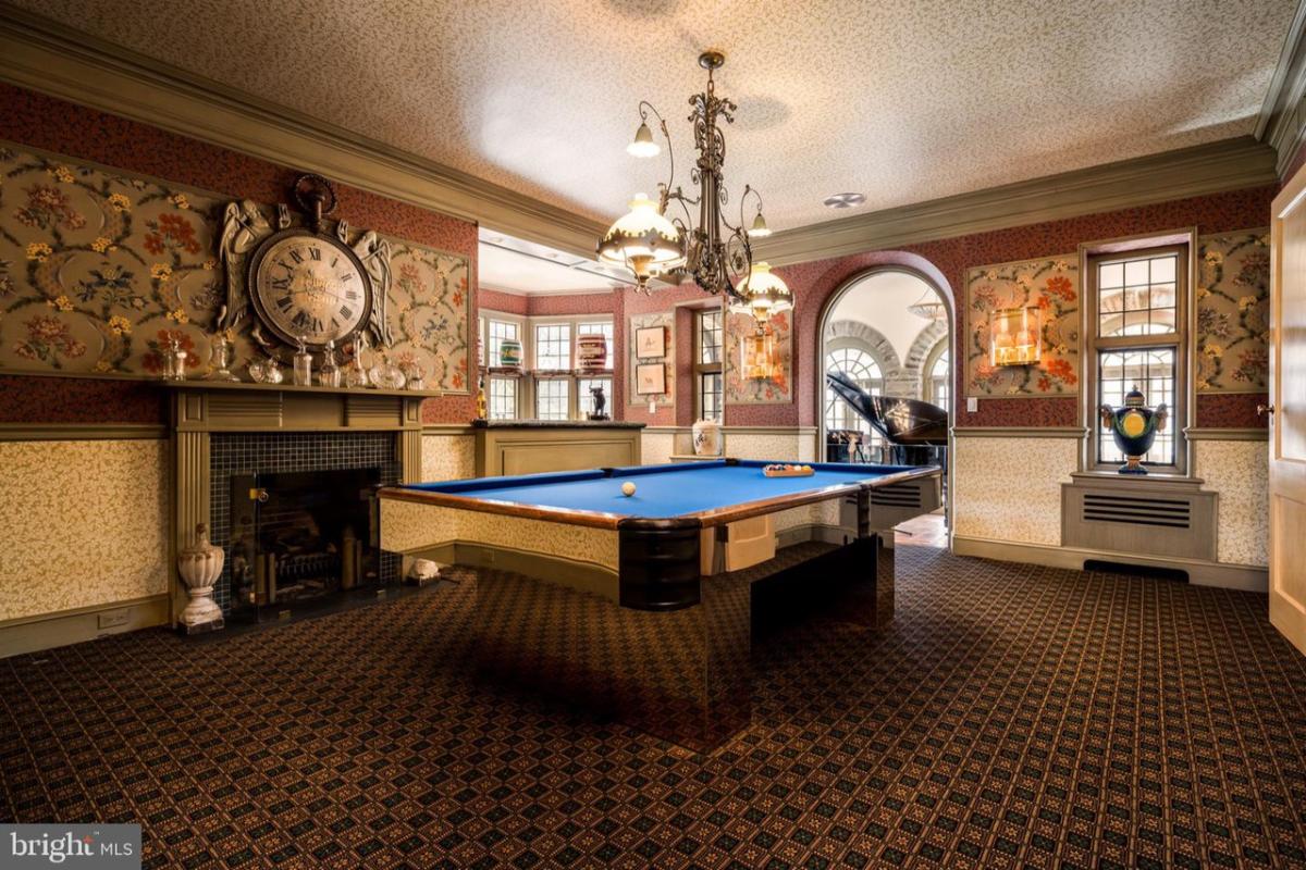Billiards room with a fireplace.
