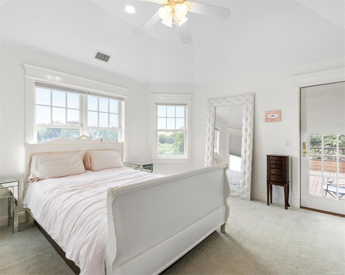 Bedroom with carpet flooring and glass windows.