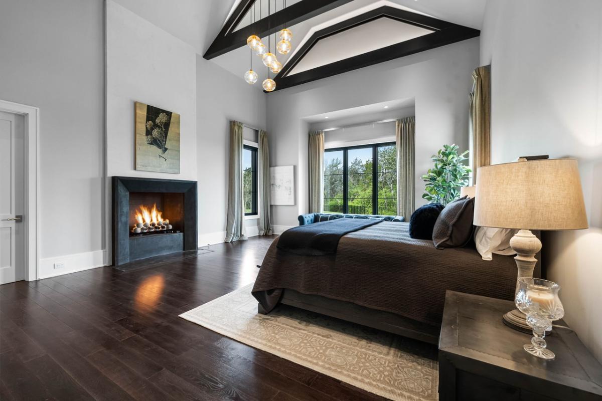 Bedroom with hardwood floors and a fireplace.