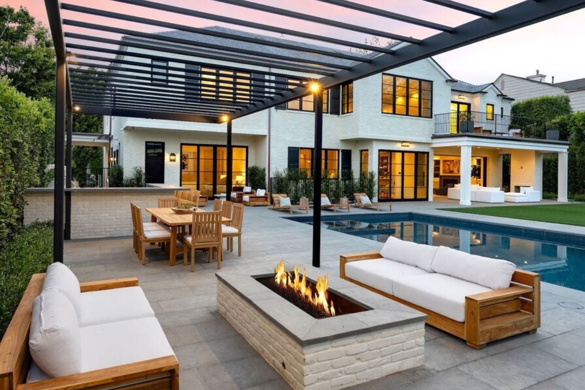 A patio with a firepit, couches, table, and chairs.
