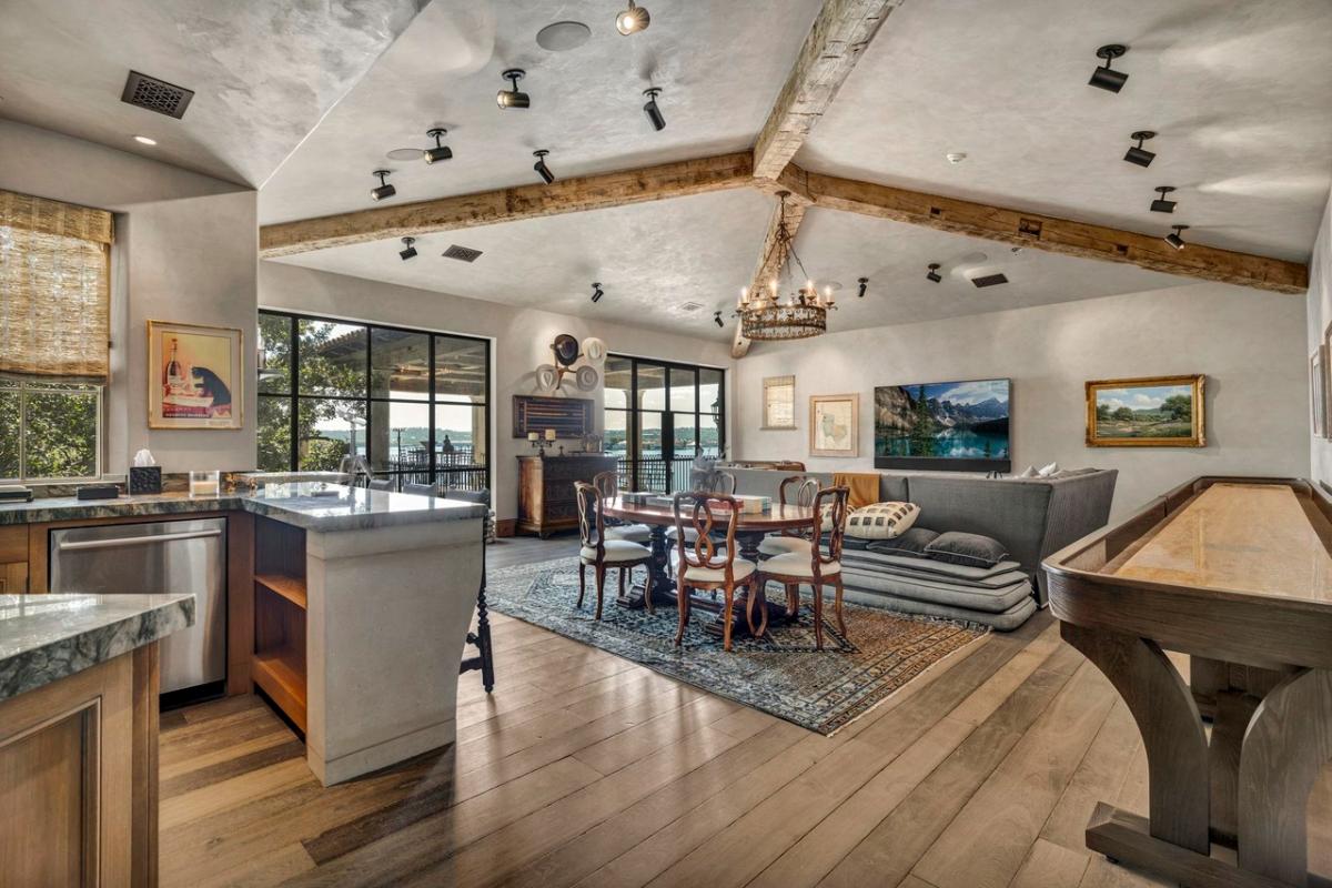 Family room with sofas, chairs, tables and a kitchen.