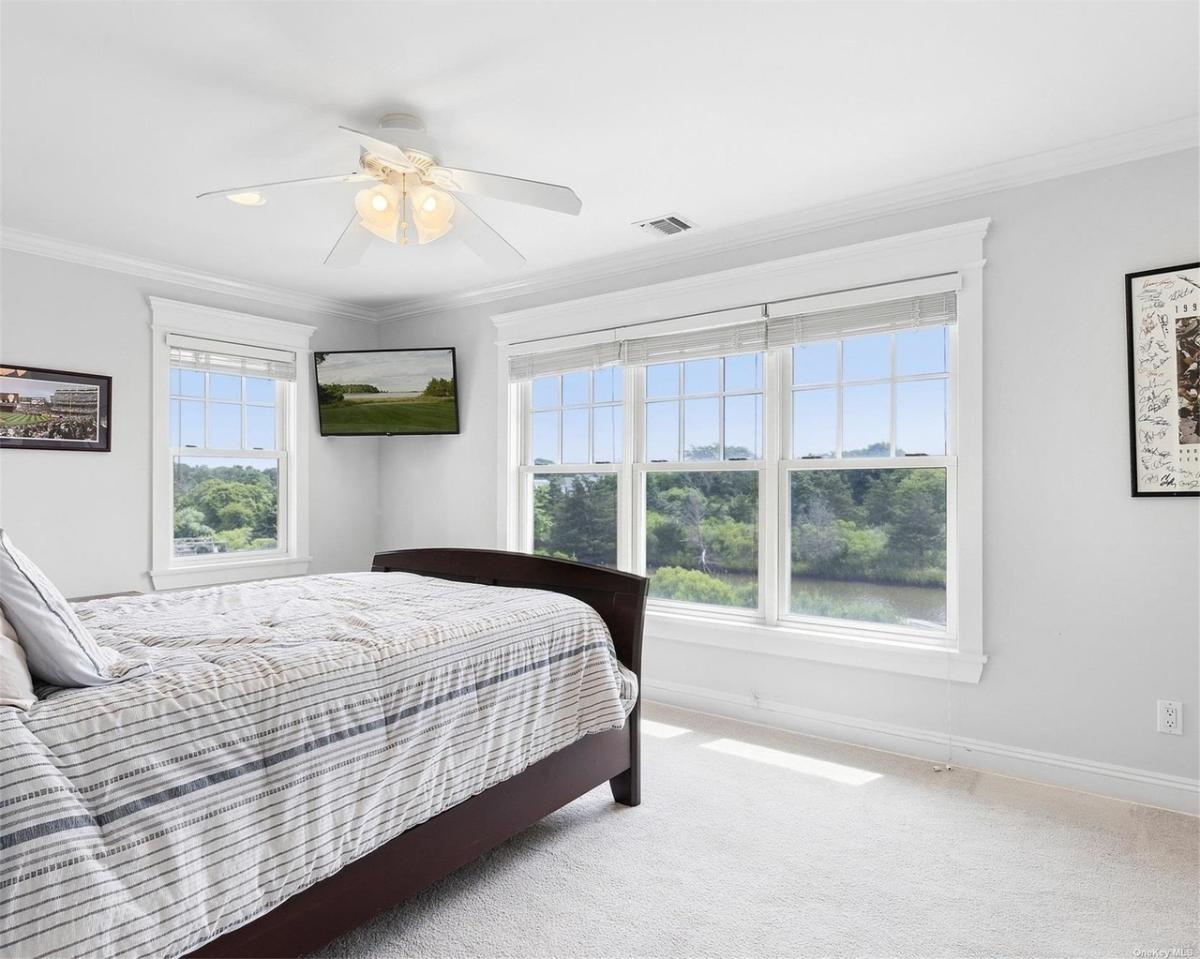 Bedroom with carpet flooring and glass windows.