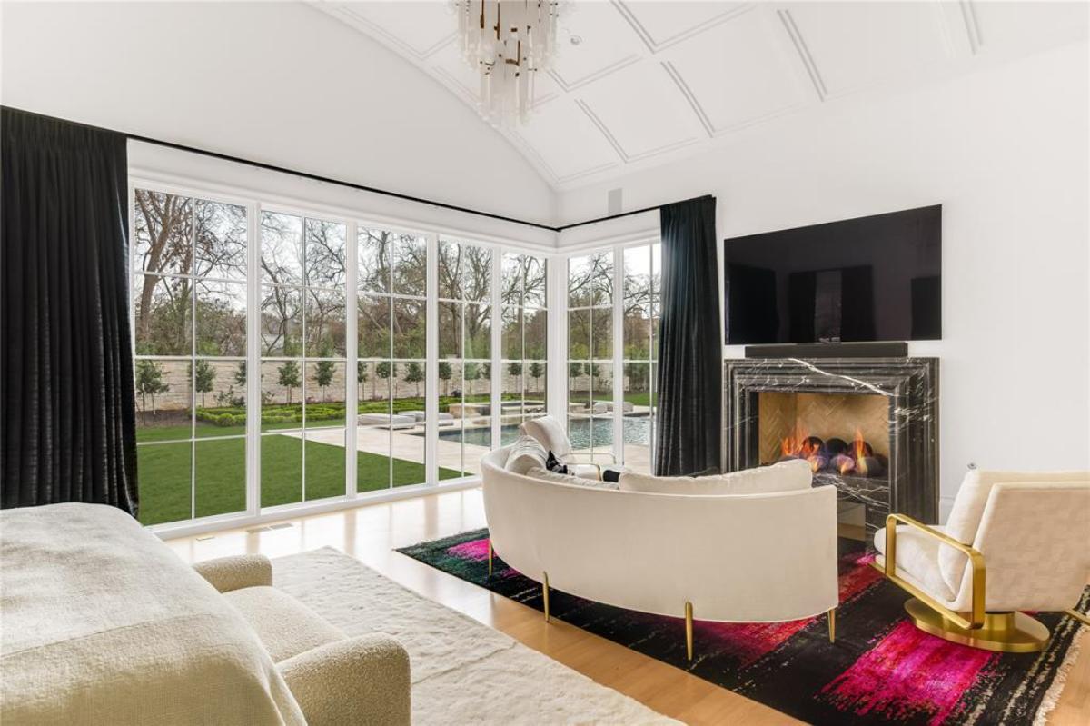 Bedroom with a chandelier, fireplace and own living space.