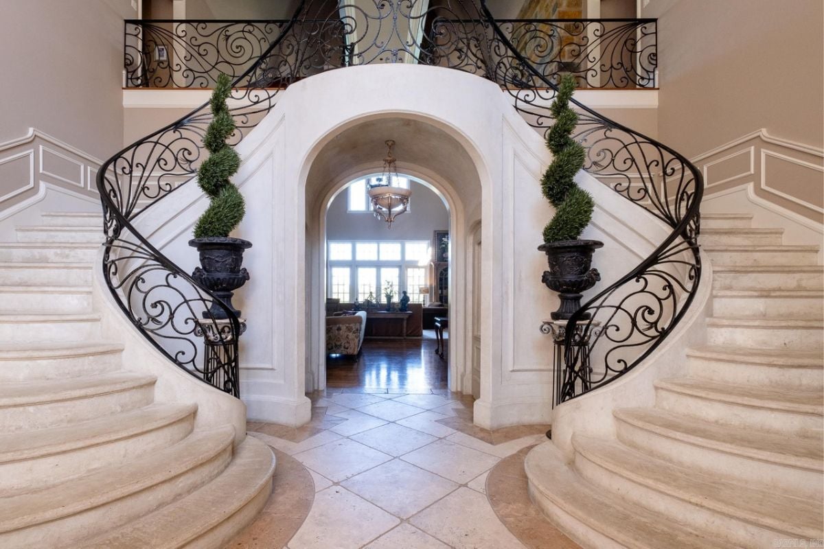 A foyer with a tiled floor and grand staircase.